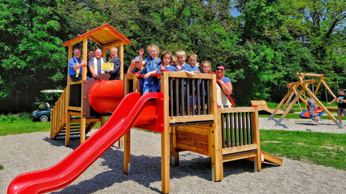 Kinder und Ehrengäste auf einem Klettergerüst bei der Eröffnung des Erlebnisspielplatzes