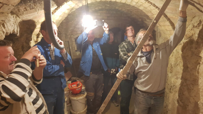 Sechs Männer arbeiten an einem Kellergewölbe