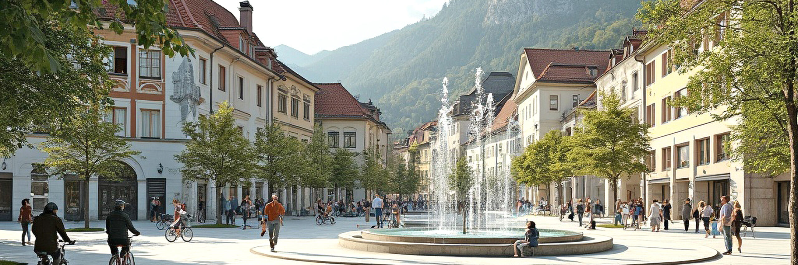 Ortszentrum mit Häusern, Platz, Straße, im Vordergrund ein Brunnen, Bäume