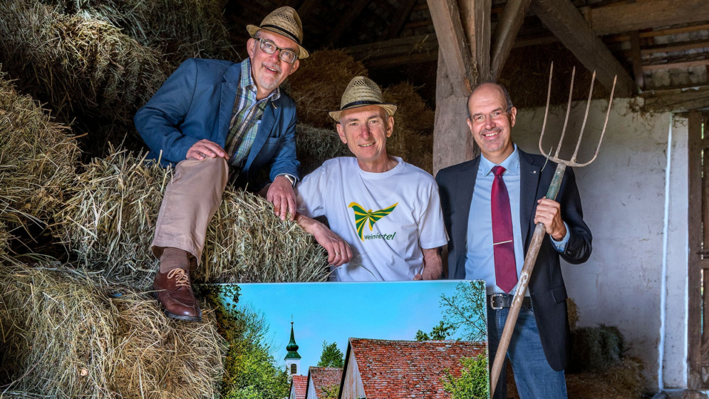 Menschen in einem heustadl mit Heugabeln