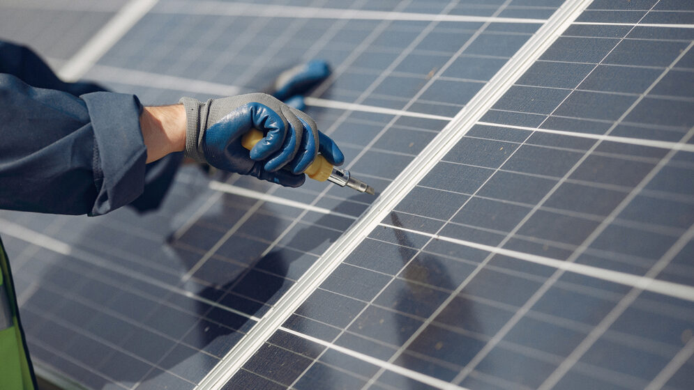 Engineer in a white helmet. Man near solar panel.